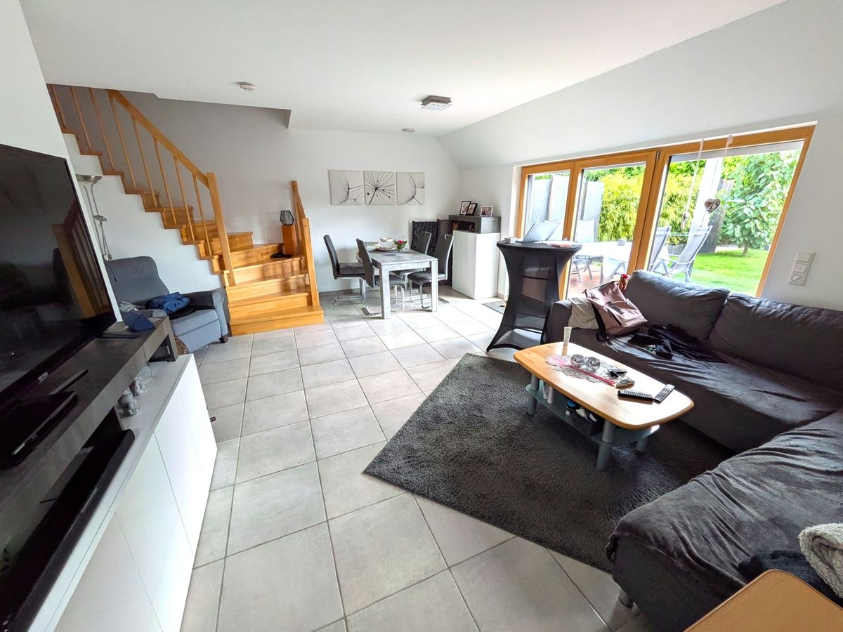 Das helle und moderne Wohnzimmer der kleinen Wohnung mit Möglichkeit in Ihren Garten zu treten