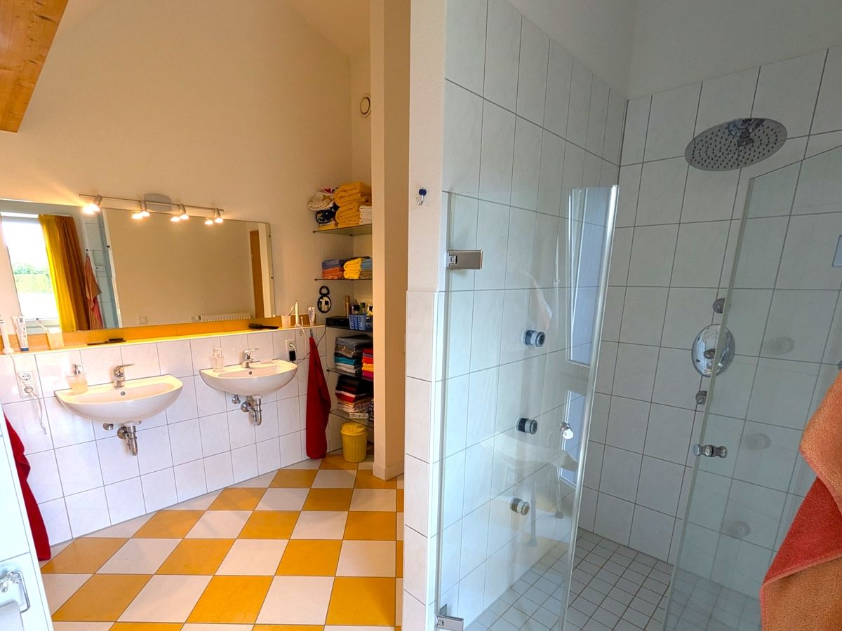 Komfortabel ist das maßgefertigte Glasregal und die bodenebene Dusche