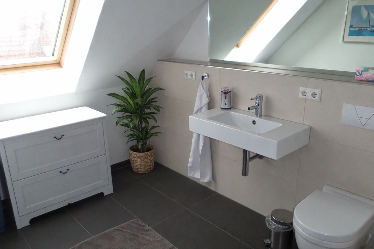 In allen Räumen, wie auch hier im modernen Badezimmer, ist Fußbodenheizung verlegt